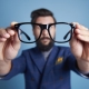 Man holding eyeglasses in front his face