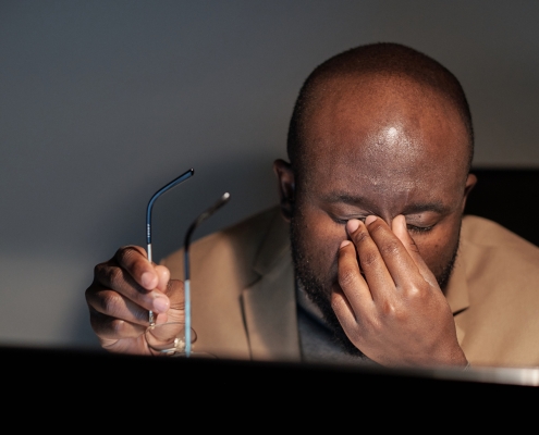 Tired businessman rubbing his eyes during night work